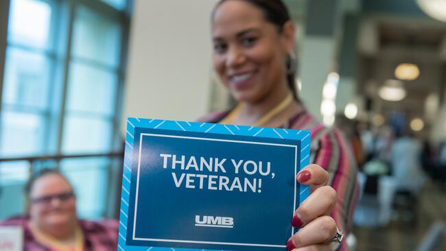 UMB associate holding a Thank you veterans card