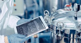 engineer monitoring digital tablet in food processing factory
