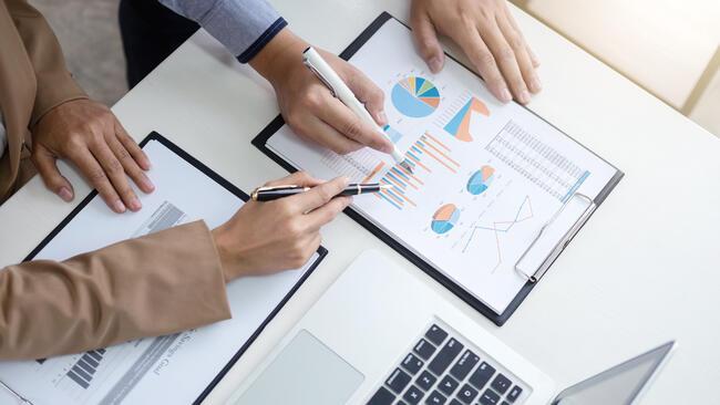 Business people reviewing charts showing hands only 